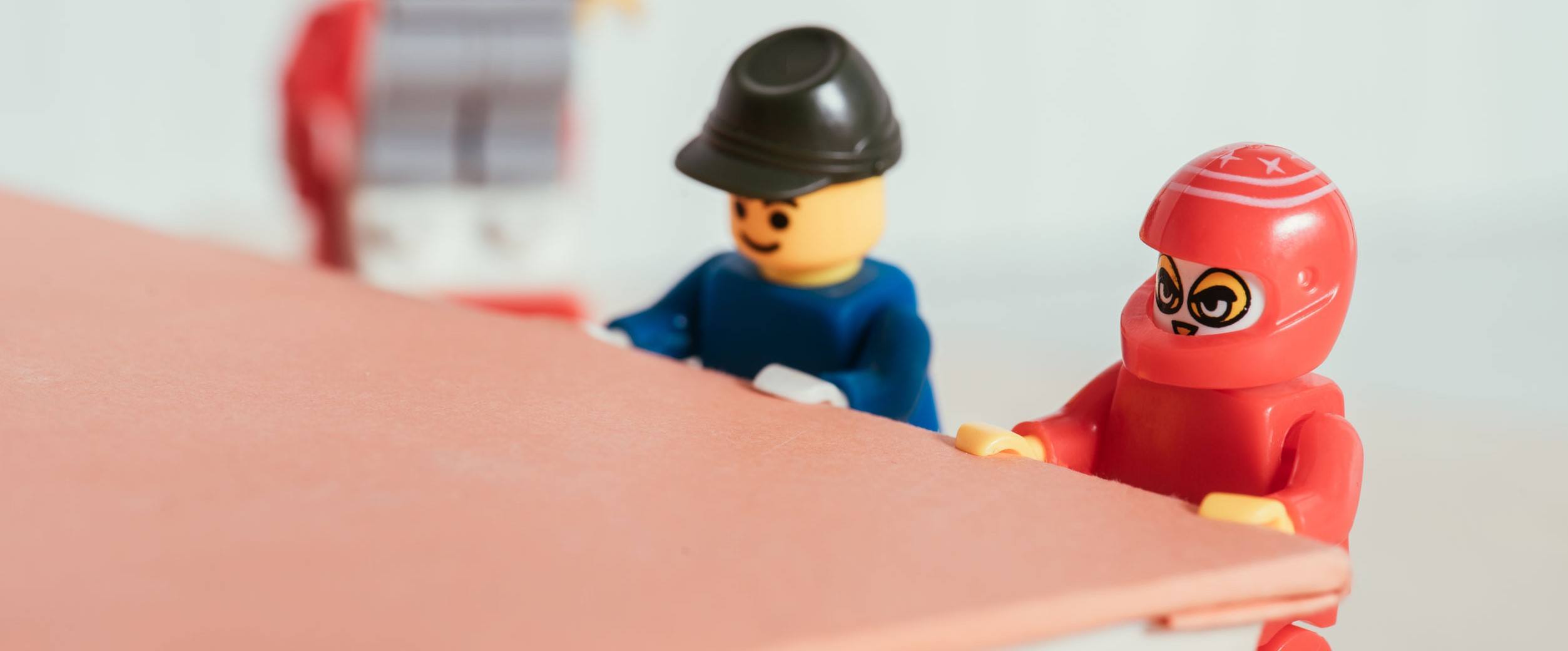 Two LEGOs doing bodyweight training on a book